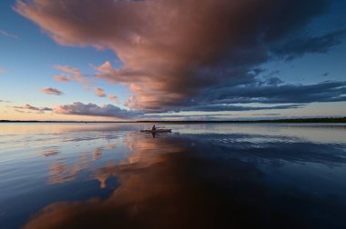 Everglades Ulusal Parkı 'ndaki Coot Bay' de kayakçılar dramatik günbatımı bulutları altında.