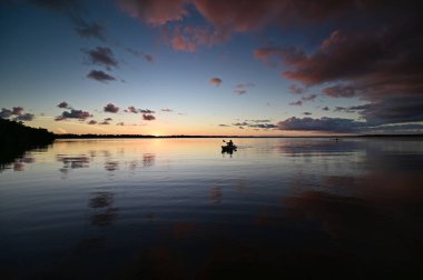 Everglades Ulusal Parkı 'ndaki Coot Bay' de kayakçılar dramatik günbatımı bulutları altında.