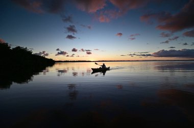 Everglades Ulusal Parkı 'ndaki Coot Bay' de kayakçılar dramatik günbatımı bulutları altında.