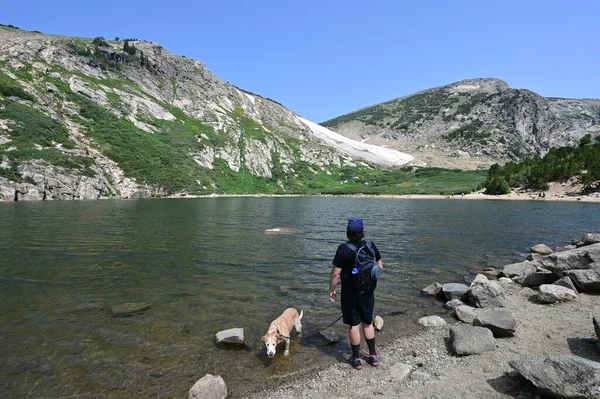 Homme et chien près du lac Saint Marys et du glacier dans la forêt d'Arapaho Natl, Colorado. — Photo