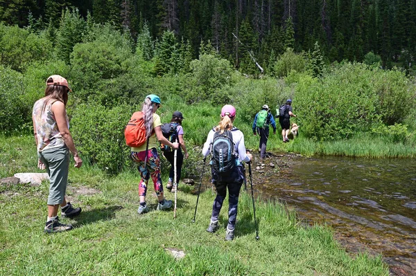 Wandelaars in ondiep water op Hassell Lake Trail in Arapaho Natl Forest, Colorado. — Stockfoto