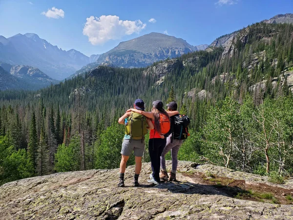 Drie jonge vrouwen wandelaars genieten van uitzicht op Rocky Mountains in Colorado. — Stockfoto