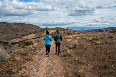Hırsızlar üzerinde yürüyüş yapan iki kadın Loma, Colorado yakınlarında fırtınalı kış bulutları altında.