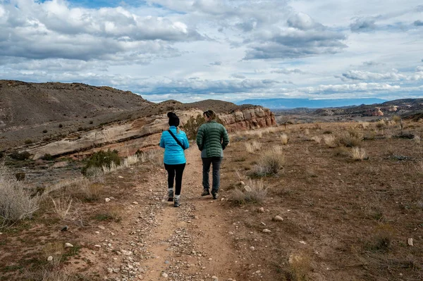Hırsızlar üzerinde yürüyüş yapan iki kadın Loma, Colorado yakınlarında fırtınalı kış bulutları altında.