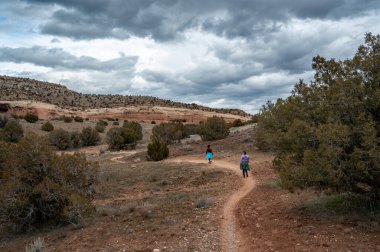 Hırsızlar üzerinde yürüyüş yapan iki kadın Loma, Colorado yakınlarında fırtınalı kış bulutları altında.