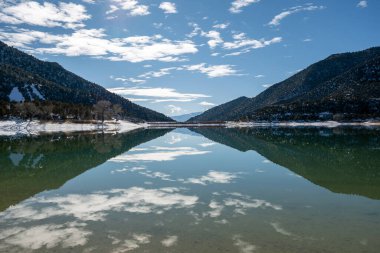 Harvey Gap State Park, Colorado 'daki Çimen Vadisi Rezervuarı üzerindeki güneşli kış sabahı bulutları sakin su rezervlerine yansıdı.