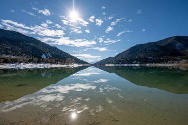 Harvey Gap State Park, Colorado 'daki Çimen Vadisi Rezervuarı üzerindeki güneşli kış sabahı bulutları sakin su rezervlerine yansıdı.