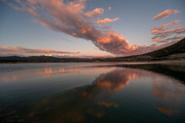 Colorado, Harvey Gap Eyalet Parkı 'ndaki Çimen Vadisi rezervuarı üzerindeki yoğun renkli günbatımı bulutları su rezervuarlarına yansıdı.