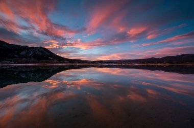 Colorado, Harvey Gap Eyalet Parkı 'ndaki Çimen Vadisi rezervuarı üzerindeki yoğun renkli günbatımı bulutları su rezervuarlarına yansıdı.