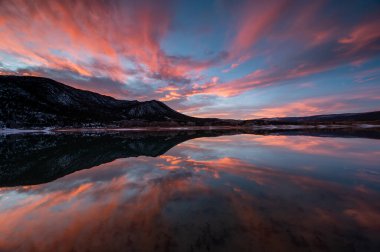 Colorado, Harvey Gap Eyalet Parkı 'ndaki Çimen Vadisi rezervuarı üzerindeki yoğun renkli günbatımı bulutları su rezervuarlarına yansıdı.