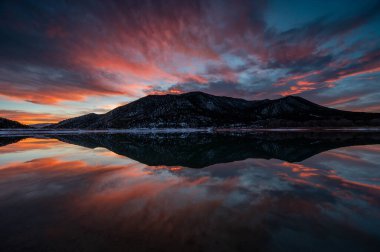 Colorado, Harvey Gap Eyalet Parkı 'ndaki Çimen Vadisi rezervuarı üzerindeki yoğun renkli günbatımı bulutları su rezervuarlarına yansıdı.