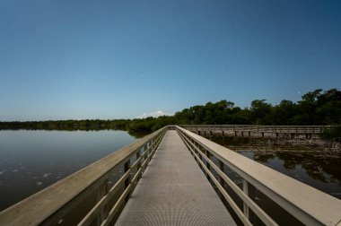 Everglades Ulusal Parkı, Florida 'daki Batı Gölü' nün üzerindeki sahil yolu dolunay ışığıyla aydınlandı..