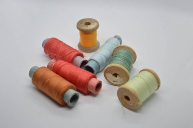 Beyaz arka planda elbise dikmek için iplikler ve makaralar