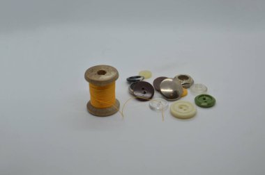 Beyaz arka planda elbise dikmek için iplikler ve makaralar