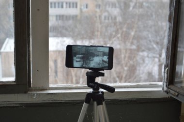 Akıllı bir telefondan tripodla fotoğraf ve video çekiyorum.
