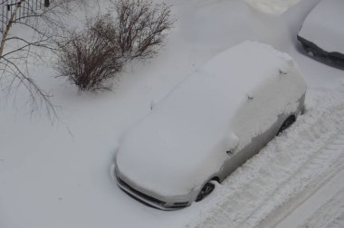 Kışın kar üstüne kar yağan arabalar.