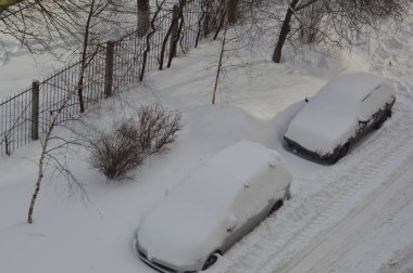 Kışın kar üstüne kar yağan arabalar.