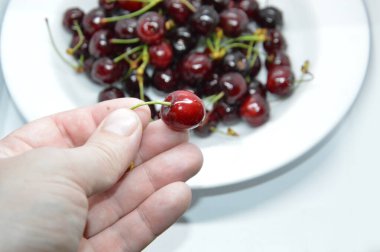 Beyaz tabakta taze kırmızı kirazlar