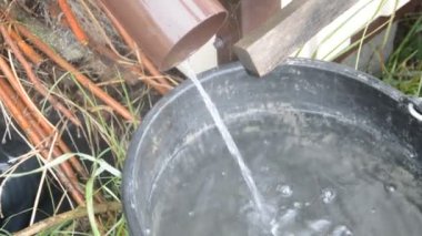 Su evden, sağanağa, kovaya dökülüyor.