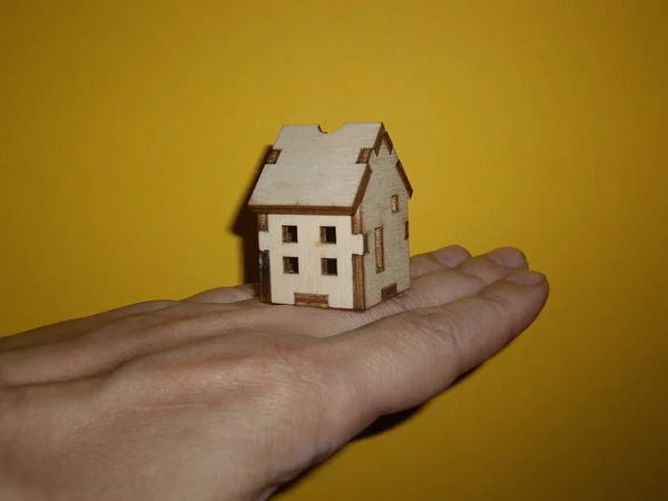 Small Wooden House Man Hand Yellow Background — Stock Photo, Image