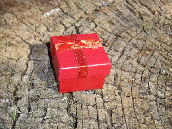赤いギフトボックスは木の切り株の上にあります — ストック写真
