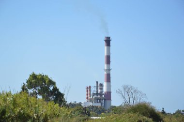 Fabrikanın bacasının dumanı tüten manzarası.