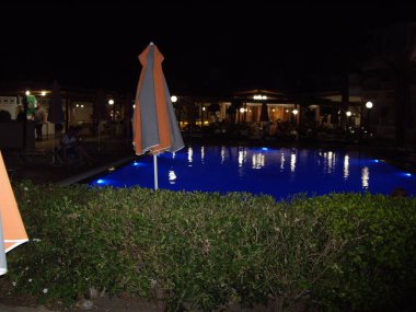 Yüzme havuzu gece maviler içinde aydınlandı.
