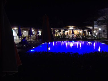 Yüzme havuzu gece maviler içinde aydınlandı.