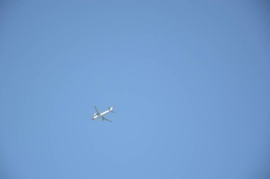 Mavi gökyüzünde bir yolcu uçağı kalkıyor.