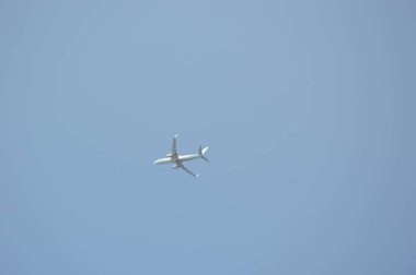 Mavi gökyüzünde bir yolcu uçağı kalkıyor.