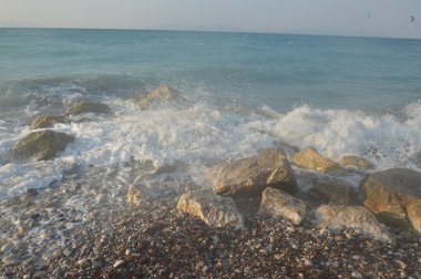 Yunanistan 'daki Rodos adasındaki Ege fırtınasının arka planında taşlar