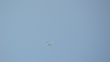 Mavi gökyüzüne karşı bir yolcu uçağı kalkıyor.