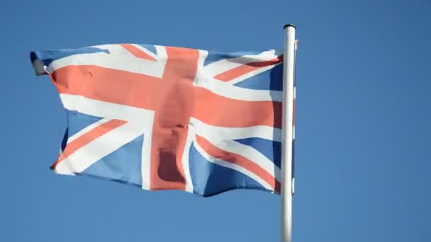 Σημαία Της Μεγάλης Βρετανίας Κυματίζει Στον Άνεμο Ενάντια Έναν Γαλάζιο — Αρχείο Βίντεο