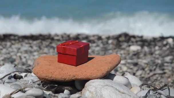 Κόκκινο Κουτί Δώρου Στο Φόντο Της Ακτής Της Θάλασσας — Αρχείο Βίντεο