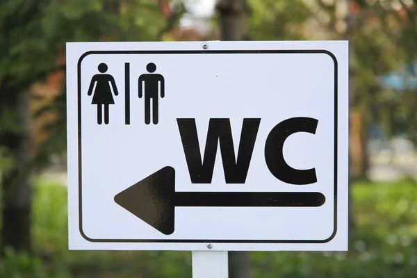 Toilet sing for man and female on white table in nature — Stock Photo, Image