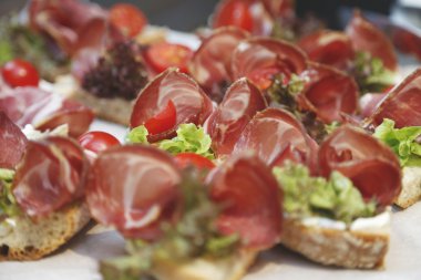 Küçük bir parti sandviç iştah açıcı jambon ve domates ile