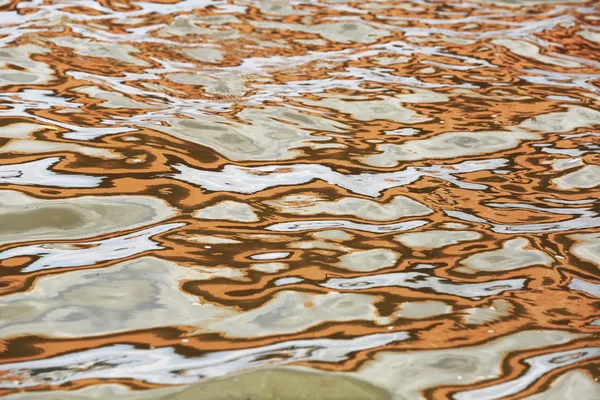 Orange blue white reflection on surface water with waves — Stock Photo, Image
