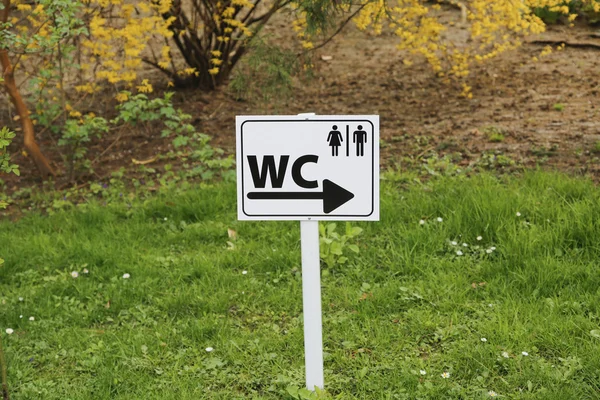 Señal de inodoro para hombre y mujer sobre mesa blanca en la naturaleza — Foto de Stock