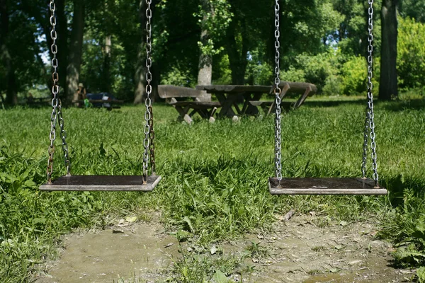Два деревянных качели в парке — стоковое фото