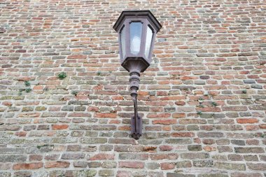Kırmızı tuğla bir duvar üzerinde eski fener