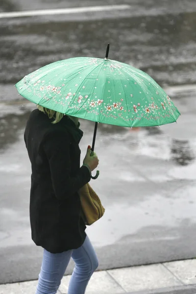 Donna con un ombrello cammina sotto la pioggia — Foto Stock