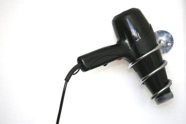 Duvara montaj aparatı üzerinde siyah saç kurutma makinesi