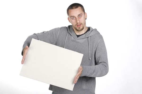 Jovem segurando uma placa em branco no fundo branco Fotografia De Stock