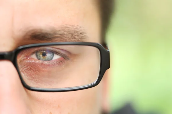 Apenas um olho de homem verde com óculos — Fotografia de Stock