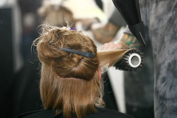 Coiffeur sèche-cheveux femme cheveux dans le salon — Photo