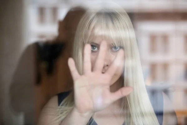 Belle jeune femme avec les mains sur la fenêtre — Photo