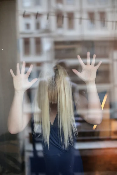 Belle jeune femme avec les mains sur la fenêtre — Photo