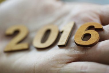Yeni yıl 2016 ahşap numaraları bir elinde tutan kadın