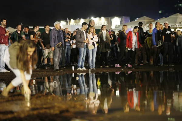 Publikum i regnen ved dammen på ølfesten - Stock-foto