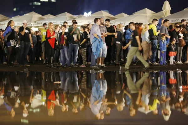El público bajo la lluvia junto al estanque en el festival de la cerveza — Foto de Stock